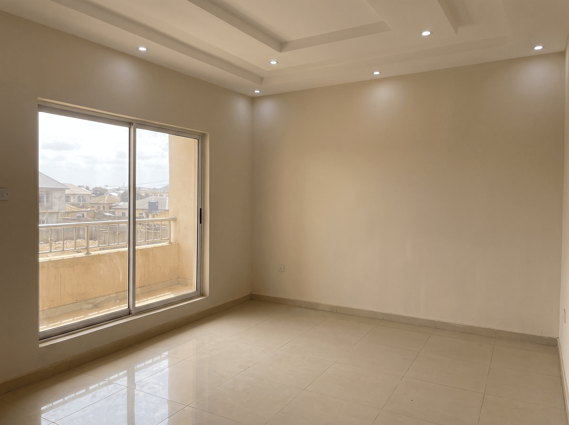 An empty, freshly finished flat with tiled floors and a balcony door